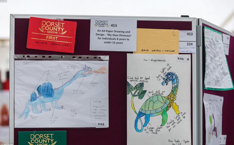 Children's hand-drawn artwork displayed at a community show