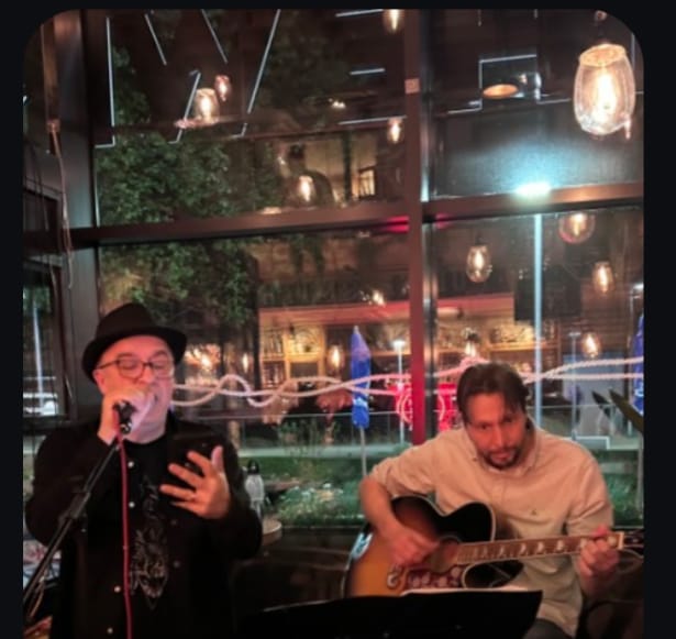 Two performers playing music at night